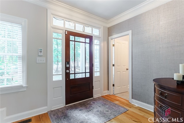 foyer entrance with light hardwood / wood-style flooring and ornamental molding