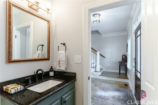 bathroom featuring crown molding, hardwood / wood-style floors, and vanity