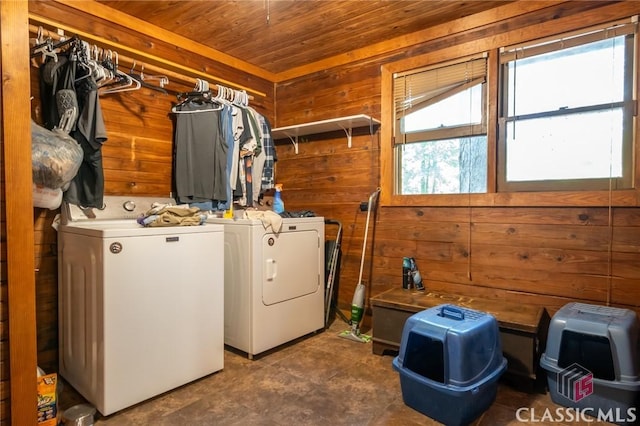 clothes washing area featuring washer and dryer, wood ceiling, and wooden walls