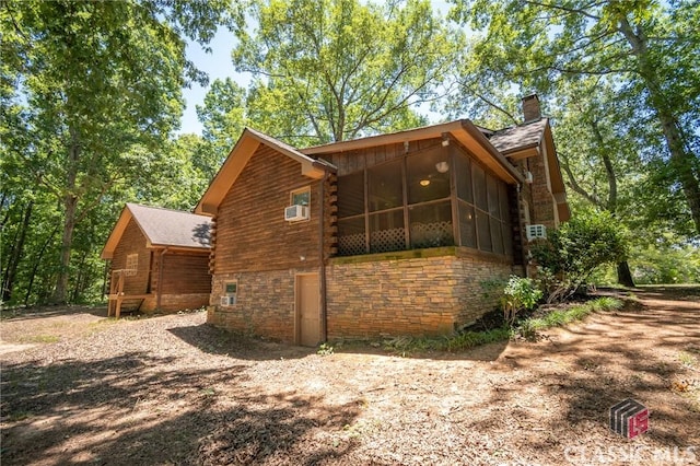 view of property exterior featuring a sunroom