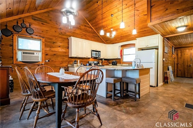 tiled dining space with wood walls, high vaulted ceiling, cooling unit, ceiling fan, and wood ceiling