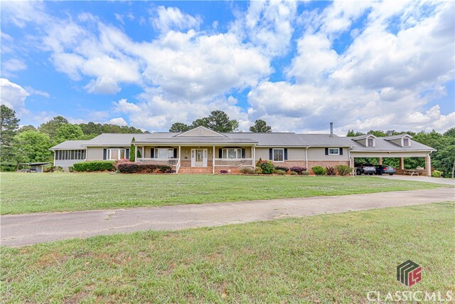 ranch-style house with covered porch, a carport, and a front lawn