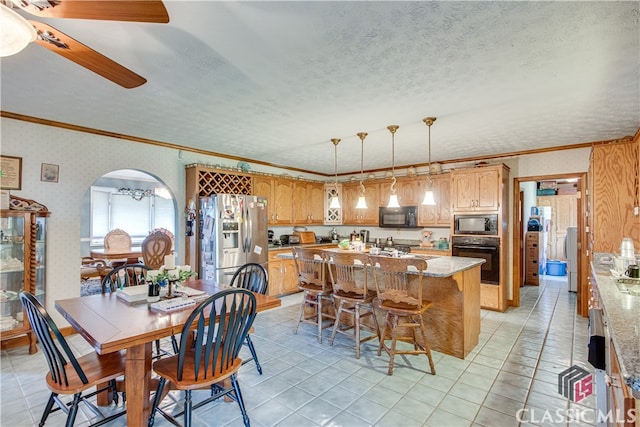 dining space featuring a textured ceiling, ceiling fan, light tile floors, and crown molding