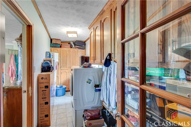 clothes washing area featuring crown molding, a textured ceiling, independent washer and dryer, and light tile floors