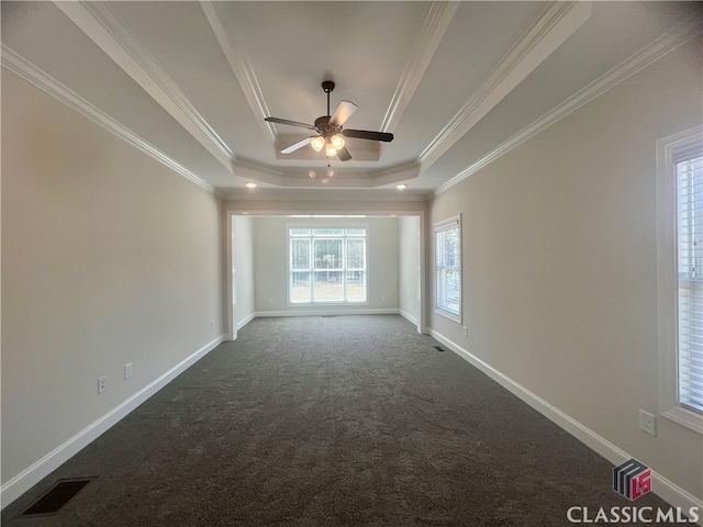 carpeted empty room with ceiling fan, ornamental molding, and a tray ceiling