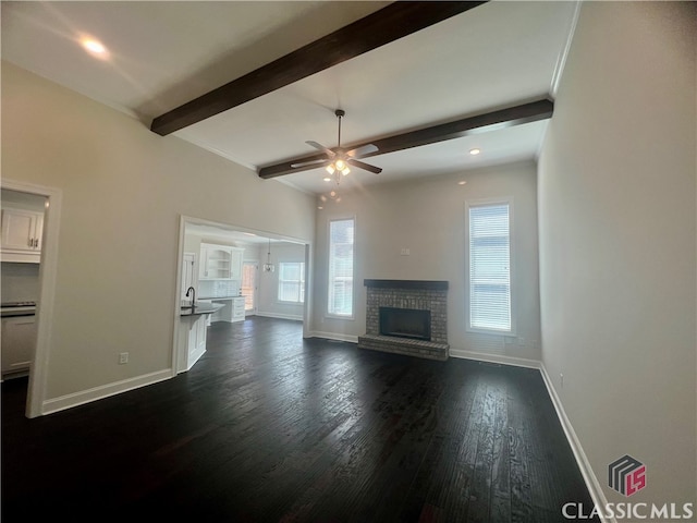 unfurnished living room with dark hardwood / wood-style floors, plenty of natural light, ceiling fan, and a fireplace