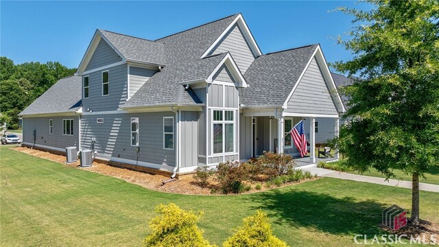 view of front of house with central AC and a front lawn