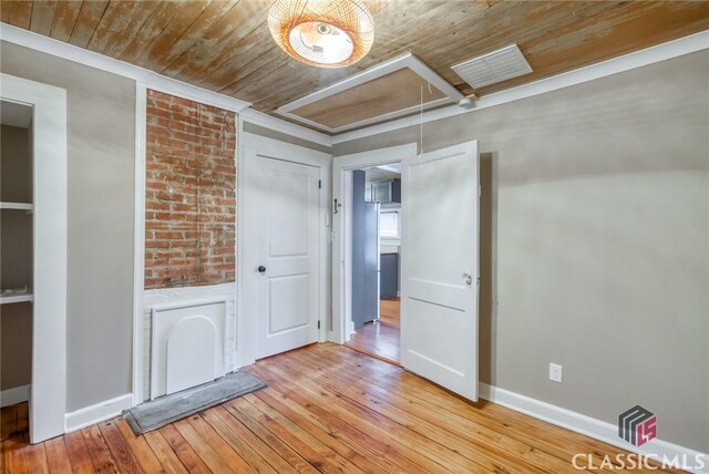 empty room with wood ceiling and light hardwood / wood-style flooring