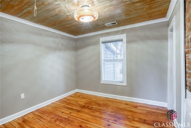 spare room featuring hardwood / wood-style flooring, crown molding, and wood ceiling