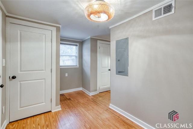 corridor with electric panel, light hardwood / wood-style floors, and crown molding