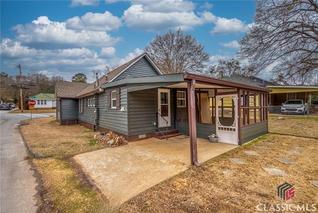 bungalow-style house with a front lawn and a carport