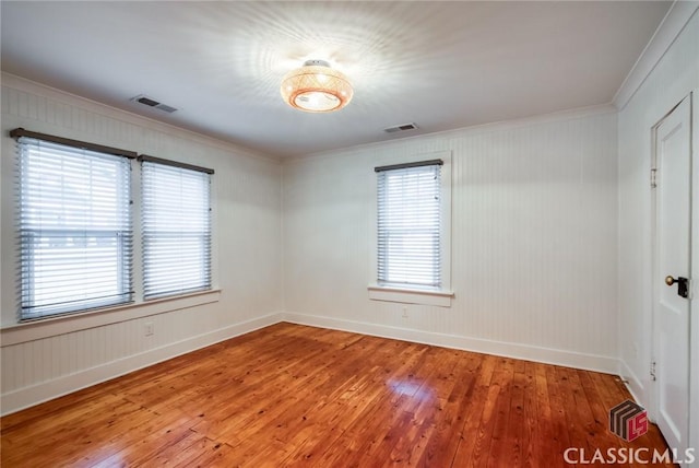 unfurnished room featuring hardwood / wood-style flooring and crown molding