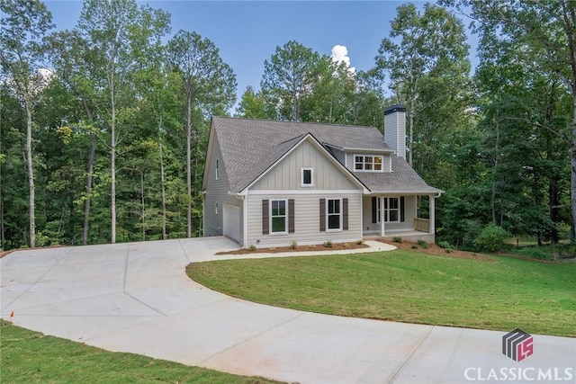 view of front of house featuring a porch, a garage, and a front yard