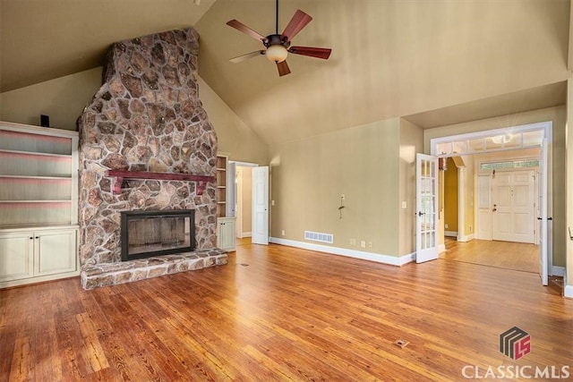 unfurnished living room featuring ceiling fan, a fireplace, hardwood / wood-style flooring, and high vaulted ceiling