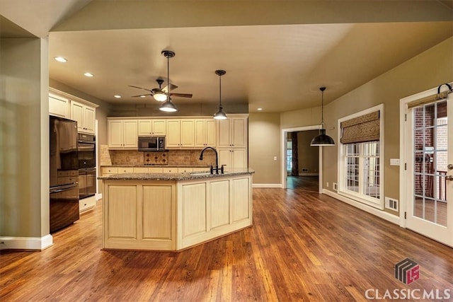 kitchen featuring ceiling fan, backsplash, black appliances, sink, and a kitchen island with sink