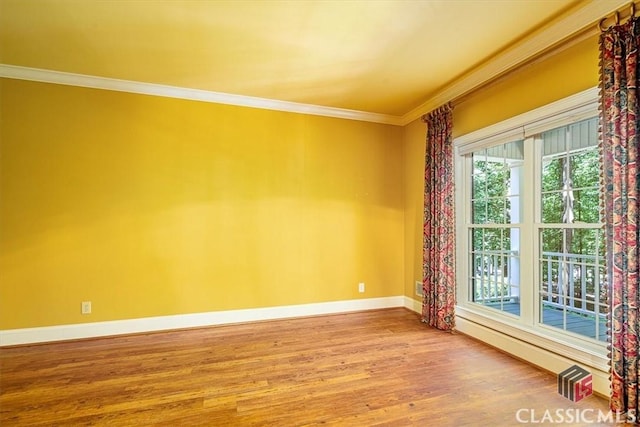 empty room with hardwood / wood-style floors and ornamental molding