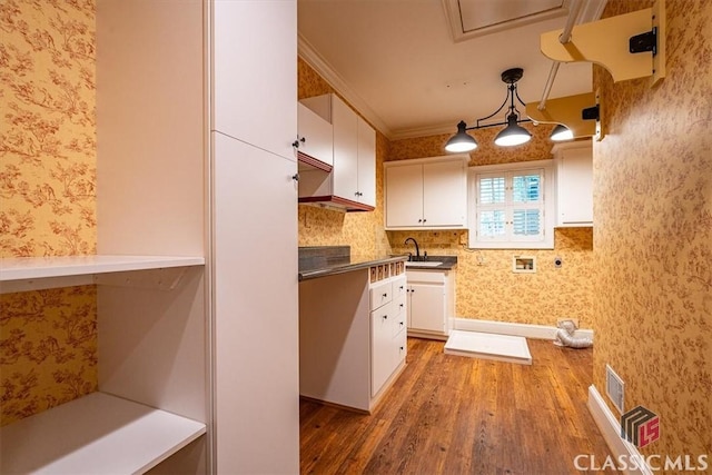 kitchen with white cabinetry, pendant lighting, dark hardwood / wood-style floors, and crown molding