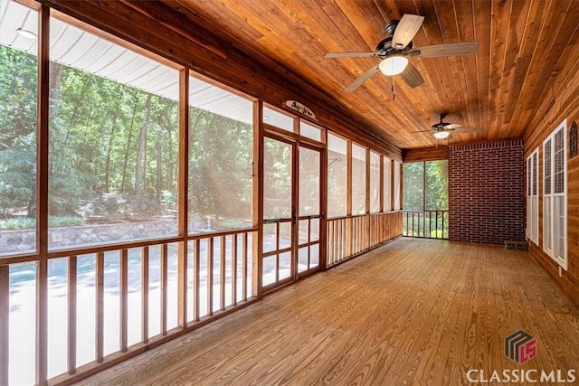 unfurnished sunroom with wooden ceiling and ceiling fan