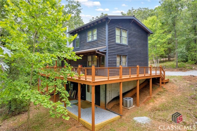 back of house with a deck, central air condition unit, and a patio