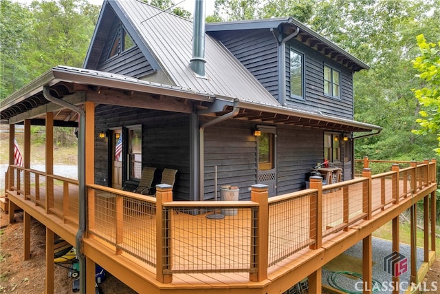 back of property featuring a wooden deck and metal roof