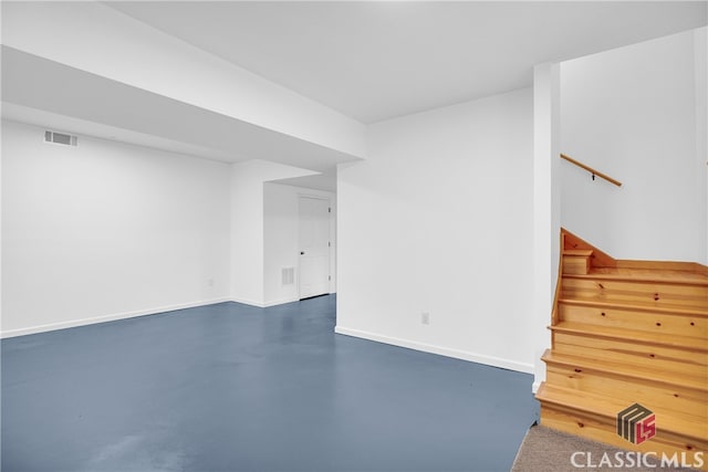 below grade area with stairs, visible vents, and baseboards