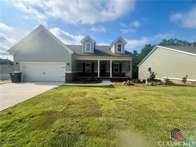 new england style home with a garage, a front yard, and covered porch