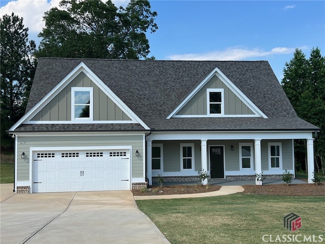 craftsman-style home with a garage, covered porch, and a front yard