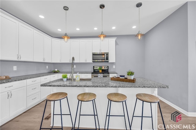 kitchen featuring light stone countertops, a center island with sink, and appliances with stainless steel finishes