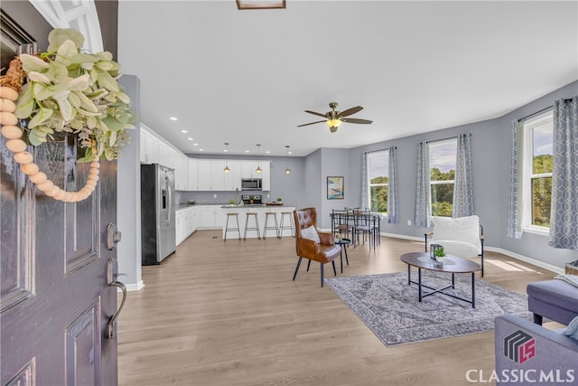 living room featuring light wood-type flooring and ceiling fan