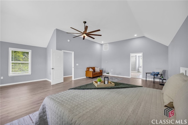 bedroom with hardwood / wood-style floors, connected bathroom, vaulted ceiling, and ceiling fan