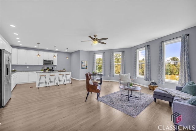 living room featuring ceiling fan and light wood-type flooring