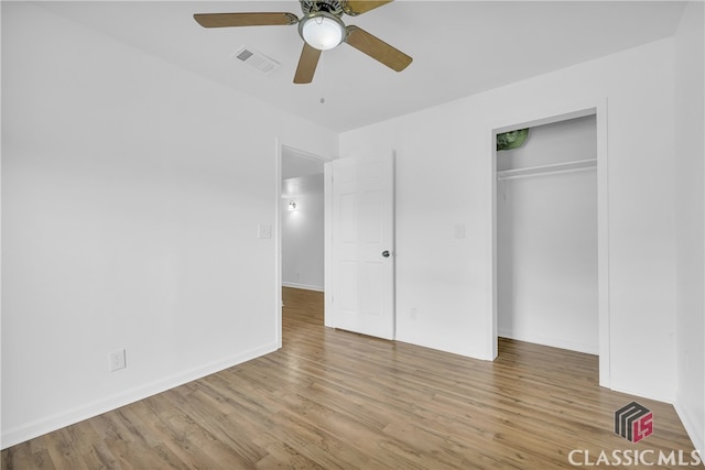 unfurnished bedroom featuring ceiling fan, light hardwood / wood-style floors, and a closet