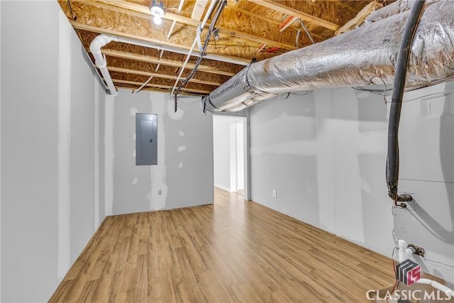 basement with wood-type flooring and electric panel