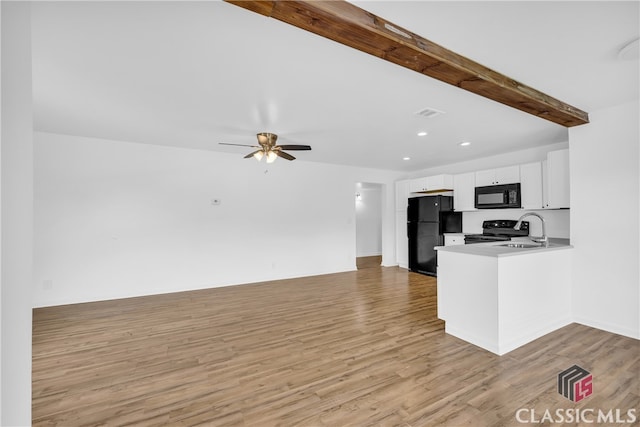 kitchen featuring kitchen peninsula, light wood-type flooring, white cabinetry, and black appliances