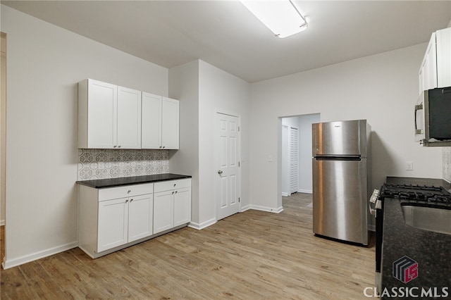 kitchen featuring stainless steel appliances, tasteful backsplash, white cabinetry, and light wood-style floors