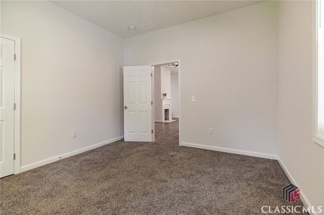 spare room featuring dark carpet