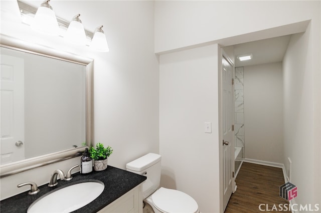 full bathroom featuring hardwood / wood-style floors,  shower combination, vanity, and toilet