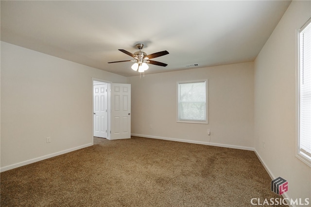 carpeted spare room featuring ceiling fan