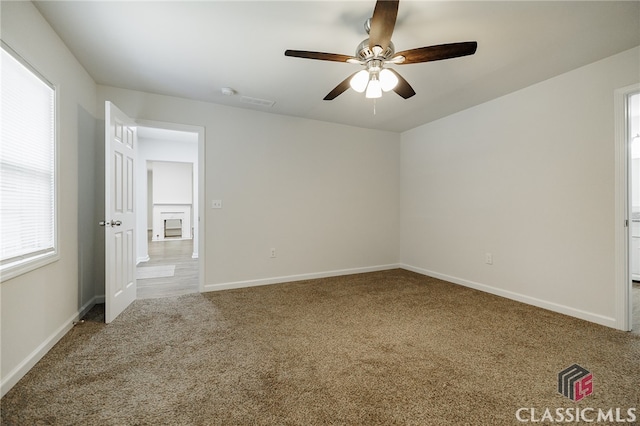 unfurnished bedroom with carpet, a ceiling fan, and baseboards