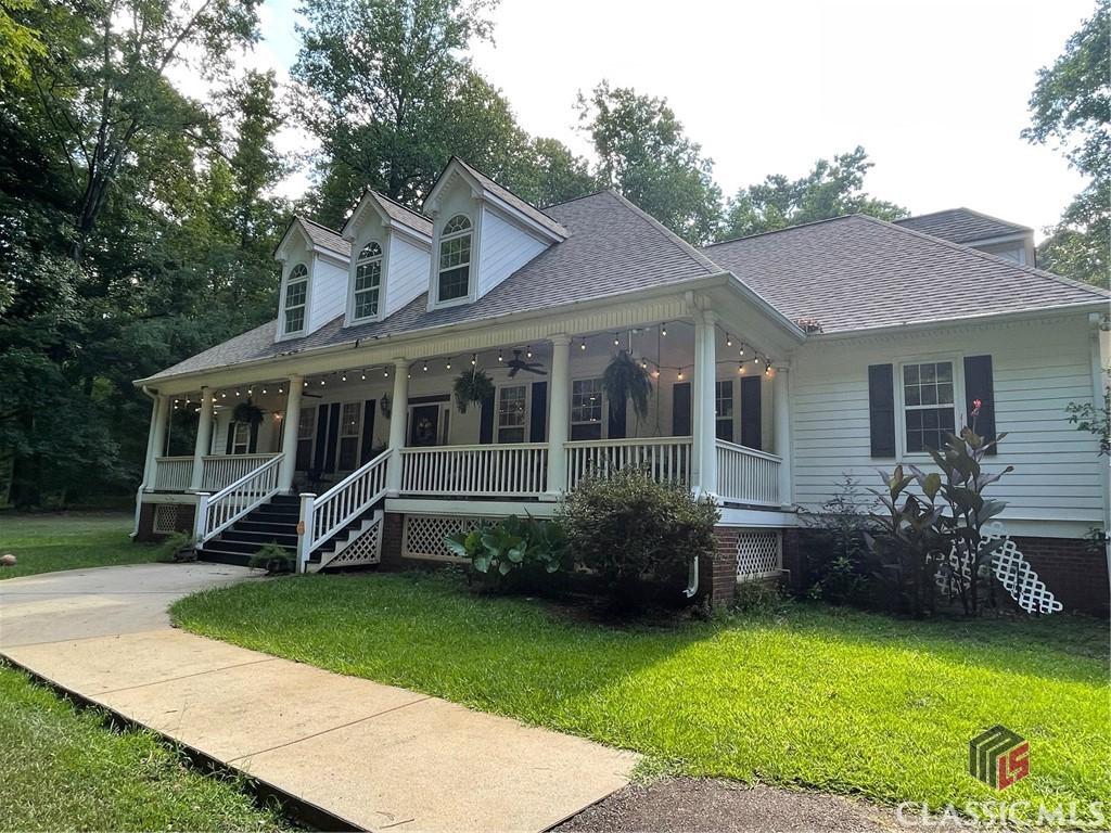 view of front of property featuring roof with shingles, a porch, and a front lawn