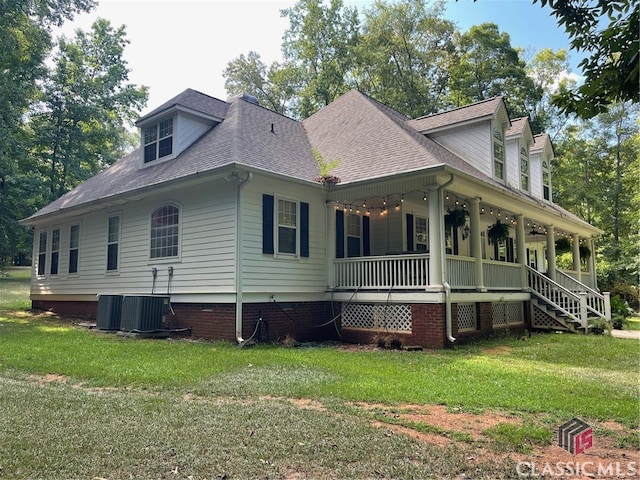 exterior space featuring central air condition unit, a front lawn, and covered porch