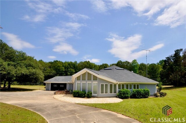 ranch-style home featuring a garage and a front lawn