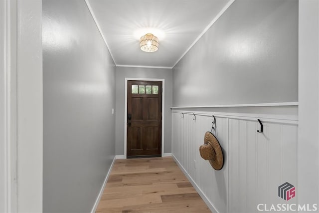 doorway to outside with ornamental molding and light wood-type flooring