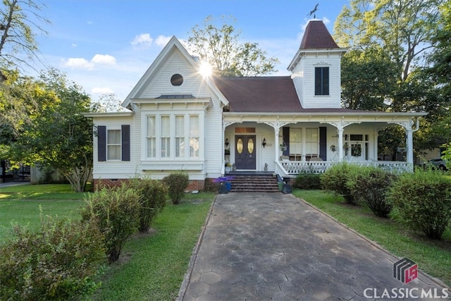 victorian home with a porch and a front yard