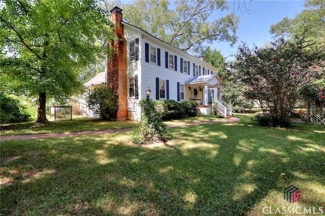 colonial-style house featuring a front yard