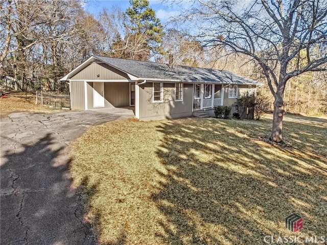 view of front of home with a front yard, driveway, and an attached carport