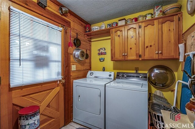 laundry area with separate washer and dryer, a textured ceiling, cabinets, and light tile patterned floors