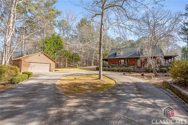 view of front of house featuring a garage, a porch, and an outbuilding