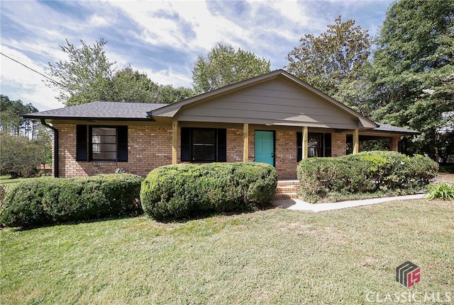 ranch-style house featuring a front yard and covered porch