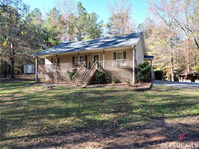 ranch-style home with a storage unit, covered porch, and a front lawn